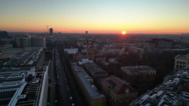 Berlins ufuk çizgisi aşağıdaki işlek yolda akan hareketli bir günbatımıyla aydınlanıyor. Sol İHA 'ya dön 