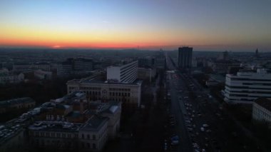 Berlins ufuk çizgisi aşağıdaki işlek yolda akan hareketli bir günbatımıyla aydınlanıyor. panorama genel görünüm dronu 