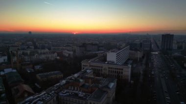 Berlins ufuk çizgisi aşağıdaki işlek yolda akan hareketli bir günbatımıyla aydınlanıyor. İHA yükseliyor 