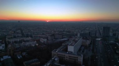 Berlins ufuk çizgisi aşağıdaki işlek yolda akan hareketli bir günbatımıyla aydınlanıyor. panorama genel görünüm dronu 