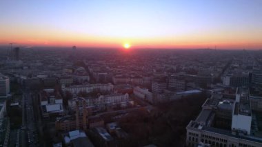 Berlins ufuk çizgisi aşağıdaki işlek yolda akan hareketli bir günbatımıyla aydınlanıyor. panorama genel görünüm dronu 