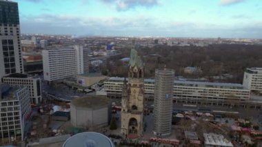 Almanya 'nın Berlin kentindeki Kaiser Wilhelm Memorial Kilisesi ile Breitscheidplatz' daki Noel pazarının hava görüntüsü. Sağ drona döndür 