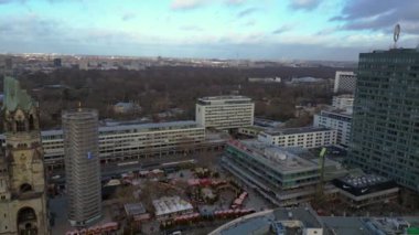 Almanya 'nın Berlin kentindeki Kaiser Wilhelm Memorial Kilisesi ile Breitscheidplatz' daki Noel pazarının hava görüntüsü. panorama genel görünüm dronu 