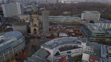 Almanya 'nın Berlin kentindeki Kaiser Wilhelm Memorial Kilisesi ile Breitscheidplatz' daki Noel pazarının hava görüntüsü. panorama yörünge dronu 