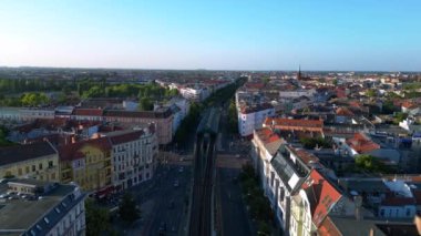 Berlin 'deki bir yerleşim bölgesinden geçen yükseltilmiş tren, şehrin taşıma sistemini gösteriyor. Ters İHA uçuşu 
