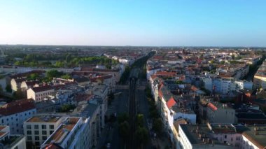 Berlin 'deki bir yerleşim bölgesinden geçen yükseltilmiş tren, şehrin taşıma sistemini gösteriyor. Ters İHA uçuşu 