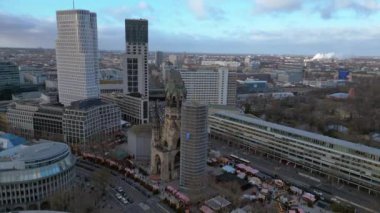 Kaiser Wilhelm Memorial Kilisesi ve Berlin, Almanya 'da Noel pazarı bulutlu bir kış gününde. statik üç ayaklı insansız hava aracı 