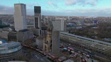 Kaiser Wilhelm Memorial Kilisesi ve Berlin, Almanya 'da Noel pazarı bulutlu bir kış gününde. Ters İHA uçuşu 