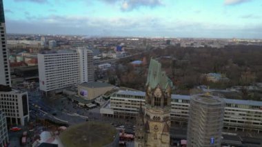 Kaiser Wilhelm Memorial Kilisesi ve Berlin, Almanya 'da Noel pazarı bulutlu bir kış gününde. Ters İHA uçuşu 