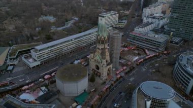 Kaiser Wilhelm Memorial Kilisesi ve Berlin, Almanya 'da Noel pazarı bulutlu bir kış gününde. İHA kamerası aşağıya bakıyor 