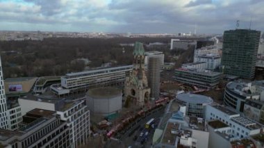 Kaiser Wilhelm Memorial Kilisesi ve Berlin, Almanya 'da Noel pazarı bulutlu bir kış gününde. panorama yörünge dronu 