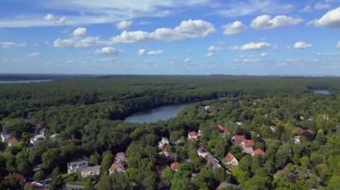 Schlachtensee gölleri, güneşli bir günde, masmavi gökyüzü ve bulutlarla çevrili yemyeşil ormanlarla çevrilidir. hız rampası hiper hareket zaman aşımı 