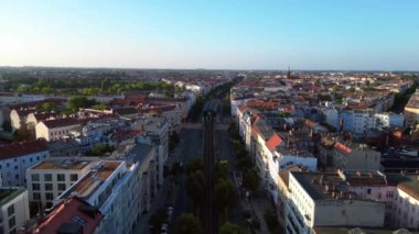 Berlin 'in yerleşim bölgesinden geçen sarı yükseltilmiş tren. Ters İHA uçuşu 