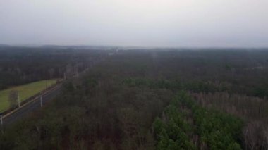 Demiryolu manzarası bulutlu gökyüzü altındaki büyük ormanı geçerek karamsar ve atmosferik manzaralar yaratıyor. İticileri ileri çalıştır 