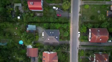 Brandenburg, Almanya 'da sakin bir akşam, çatıların, yemyeşil otlakların ve bir yol ağının sergilendiği bir yerleşim alanına iniyor. İHA kamerası aşağıya bakıyor 