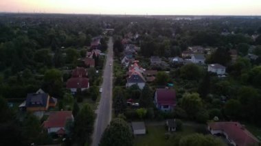 Brandenburg, Almanya 'da sakin bir akşam, çatıların, yemyeşil otlakların ve bir yol ağının sergilendiği bir yerleşim alanına iniyor. uçuş üstü insansız hava aracı 