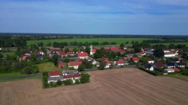 Almanya 'nın Brandenburg kentinde güneşli bir yaz gününde geniş tarım sahalarının ortasına kurulmuş küçük bir köy olan Tarmow' un Idyllic manzarası. hız rampası hiper hareket zaman aşımı 