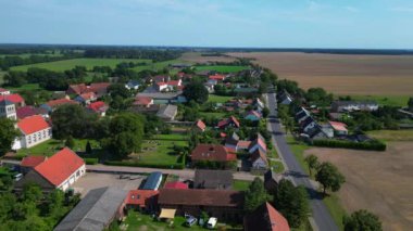 Almanya 'nın Brandenburg kentinde güneşli bir yaz gününde geniş tarım sahalarının ortasına kurulmuş küçük bir köy olan Tarmow' un Idyllic manzarası. Yukarıdan insansız hava aracı görüntüleri 