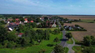 Almanya 'nın Brandenburg kentinde güneşli bir yaz gününde geniş tarım sahalarının ortasına kurulmuş küçük bir köy olan Tarmow' un Idyllic manzarası. Ters İHA uçuşu 