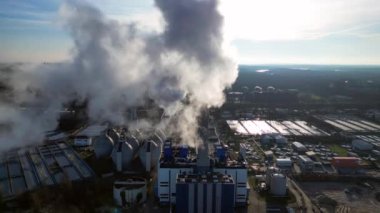 Endüstriyel bacalar mavi gökyüzünün altında beyaz duman yayıyor, kirlilik kavramı. statik üç ayaklı insansız hava aracı 