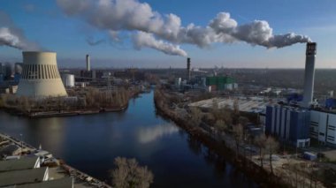 Güneşli bir günde şehrin üzerine büyük miktarlarda duman salan büyük bir sanayi enerji santralinin havadan görüntüsü. statik üç ayaklı insansız hava aracı 