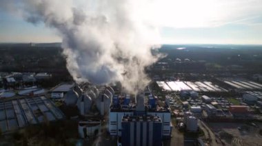 Endüstriyel bacalar mavi gökyüzünün altında beyaz duman yayıyor, kirlilik kavramı. İHA alçalıyor 