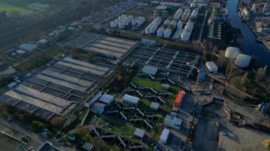 Kentsel suyu arıtan atık su arıtma tesisi, tortu tanklarını, hava tanklarını ve açıklayıcıları gösteren hava manzarası. panorama yörünge dronu 