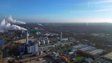 Güneşli bir günde şehrin üzerine büyük miktarlarda duman salan büyük bir sanayi enerji santralinin havadan görüntüsü. panorama genel görünüm dronu 