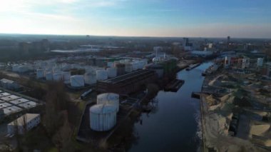 Gün batımında yanındaki nehre yansıyan büyük beyaz tanklarıyla Berlin 'deki biyogaz fabrikasının hava görüntüsü. Dolly sol İHA 