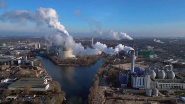 Güneşli bir günde şehrin üzerine büyük miktarlarda duman salan büyük bir sanayi enerji santralinin havadan görüntüsü. Sağ drona döndür 