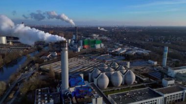 Atık atıkların enerji santraline uçarak bacasından çıkan dumanın kentsel bir alana yakın bir yere yayılması, atıkların çevresel etkileri. İHA kamerası aşağıya bakıyor 