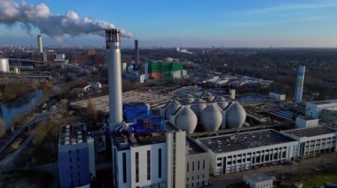 Atık atıkların enerji santraline uçarak bacasından çıkan dumanın kentsel bir alana yakın bir yere yayılması, atıkların çevresel etkileri. statik üç ayaklı insansız hava aracı 