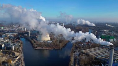 Atık atıkların enerji santraline uçarak bacasından çıkan dumanın kentsel bir alana yakın bir yere yayılması, atıkların çevresel etkileri. panorama genel görünüm dronu 