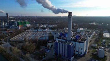 Atık atıkların enerji santraline uçarak bacasından çıkan dumanın kentsel bir alana yakın bir yere yayılması, atıkların çevresel etkileri. statik üç ayaklı insansız hava aracı 