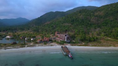 Tayland 'ın Koh Chang kentinde, palmiye ağaçları ve bir göl ile çevrili çürüyen binaları gösteren terk edilmiş bir tatil köyünün havadan görüntüsü. panorama genel görünüm dronu 