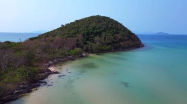 Tayland 'daki Koh Mak adası kıyılarında tropikal bitki örtüsünün berrak suyla buluşmasını gösteren hava manzarası. geniş yörünge görünümü dronu 