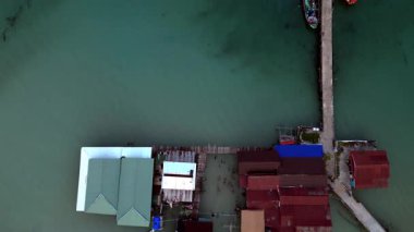Song Saa Özel Adası 'nın havadan görünüşü, iki adayı bir rıhtım ve deniz aşırı bungalovlara bağlayan lüks bir tatil yeri. Drone 'u yukarı eğ 