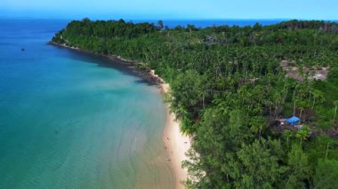 Kamboçya 'daki Koh Rong' da turkuaz suyu ve yeşil ormanlı ıssız bir sahil manzarası. İticileri ileri çalıştır 