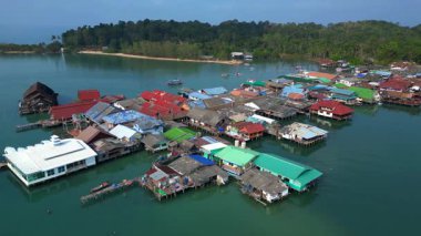 Bang Bao İskelesi yüzen köyü Tayland 'ın Koh Chang adasında renkli evler ve turkuaz sularda yüzen tekneler gösteriyor. panorama yörünge dronu 