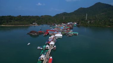 Bang Bao İskelesi yüzen köyü Tayland 'ın Koh Chang adasında renkli evler ve turkuaz sularda yüzen tekneler gösteriyor. geniş yörünge görünümü dronu 