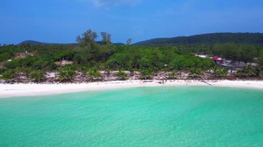 Beyaz kumu yıkayan turkuaz suyla Sok San Sahili 'nin havadan görünüşü. Palmiye ağaçları ve tropikal bitki örtüsüyle çevrili. Dolly sol İHA 