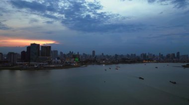 Phnom Penh ufuk çizgisi günbatımında Mekong nehrine renkli bulutlar ve arka planda bir köprüyle yansıyor. Sağ drona döndür 