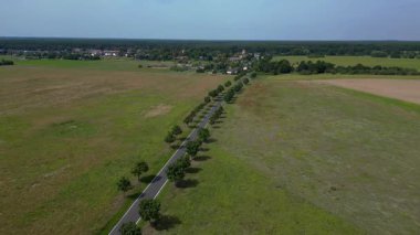 Yol, ağaçlar ve ekilmiş tarlaları olan kırsal bir arazinin havadan görünüşü. hız rampası hiper hareket zaman aşımı 