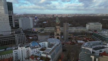 Kaiser Wilhelm Memorial Kilisesi ve Berlin, Almanya 'da Noel pazarı bulutlu bir kış gününde. Ters İHA uçuşu 