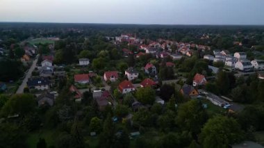 Brandenburg, Almanya 'da sakin bir akşam, çatıların, yemyeşil otlakların ve bir yol ağının sergilendiği bir yerleşim alanına iniyor. Yukarıdan insansız hava aracı görüntüleri 