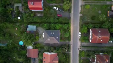 Brandenburg, Almanya 'da sakin bir akşam, çatıların, yemyeşil otlakların ve bir yol ağının sergilendiği bir yerleşim alanına iniyor. İHA kamerası aşağıya bakıyor 