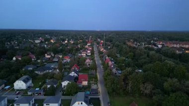 Brandenburg, Almanya 'da sakin bir akşam, çatıların, yemyeşil otlakların ve bir yol ağının sergilendiği bir yerleşim alanına iniyor. Ters İHA uçuşu 