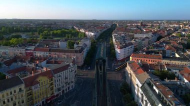 Berlin 'in yerleşim bölgesinden geçen sarı yükseltilmiş tren. Yukarıdan insansız hava aracı görüntüleri 
