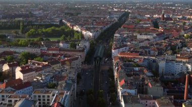 Berlin 'deki bir yerleşim bölgesinden geçen yükseltilmiş tren, şehrin taşıma sistemini gösteriyor. İHA alçalıyor 