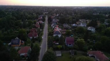 Brandenburg, Almanya 'da sakin bir akşam, çatıların, yemyeşil otlakların ve bir yol ağının sergilendiği bir yerleşim alanına iniyor. uçuş üstü insansız hava aracı 